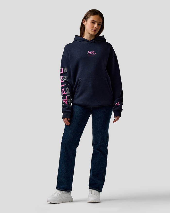 Model wearing navy unisex relaxed fit hoodie with BWT Alpine chest logo and sleeve graphics, hooded with kangaroo pocket